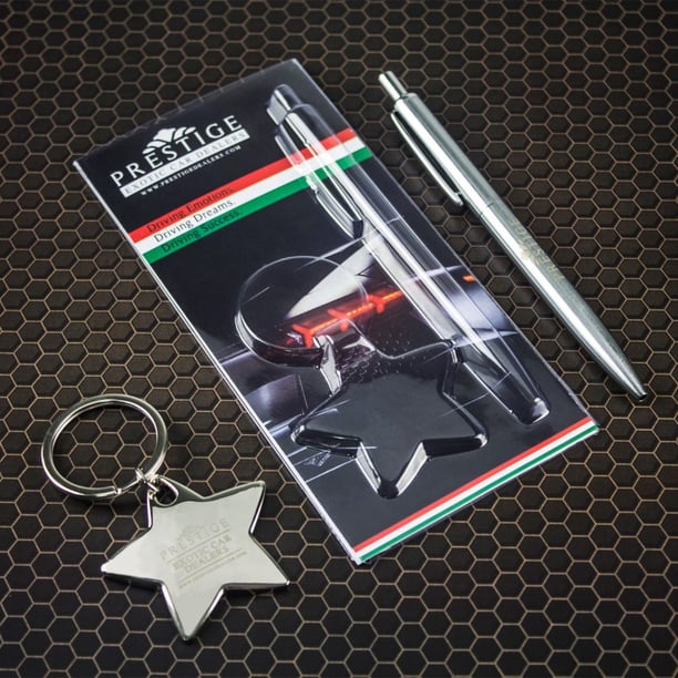Photo of engraved silver keyring and silver pen set on black background