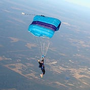 Person skydiving with parachute open